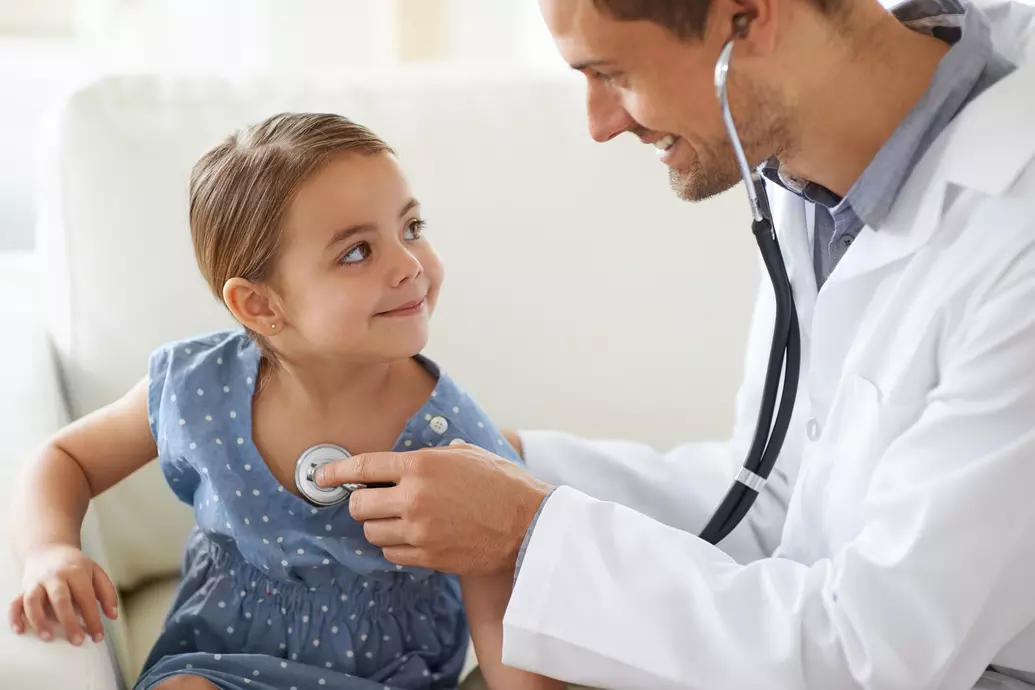 Médico consultando menina com estetoscópio